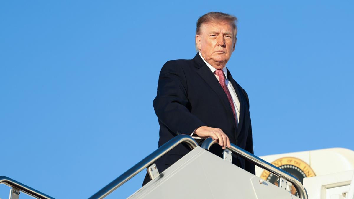 Donald Trump egy repülőgép lépcsőjén áll