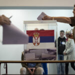 Feszült választási éjszaka Szerbiában: fekete ruhás férfiak gyülekeznek, felvonult a csendőrség Belgrádban szerbiai választásokon a szavazóurnába voksot dobnak be